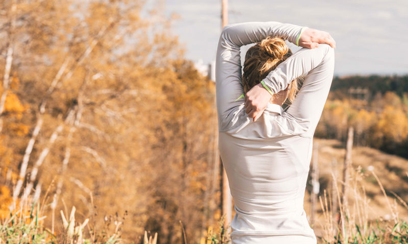 Woman stretching her back outside