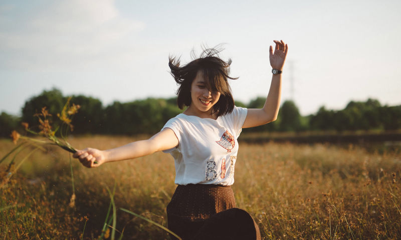 Woman in field dancing with flowers