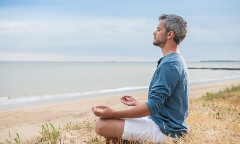 Man on the beach meditating