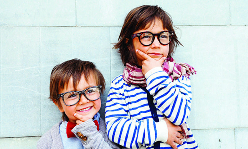 Two kids against a wall with glasses