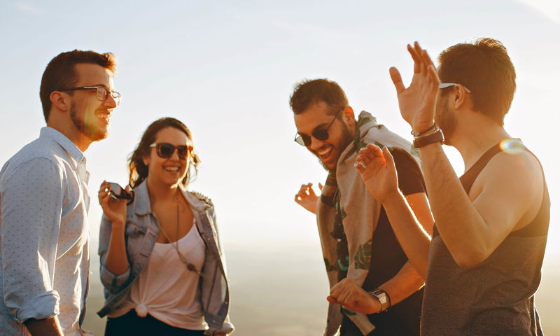 Four young people all wearing sunglasses