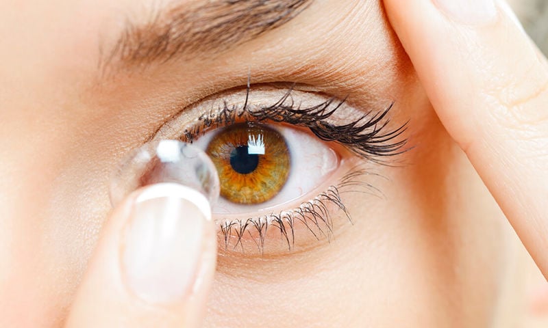 Brown eye woman putting in contacts