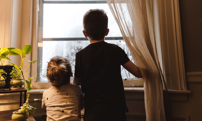 Two children looking out the window 