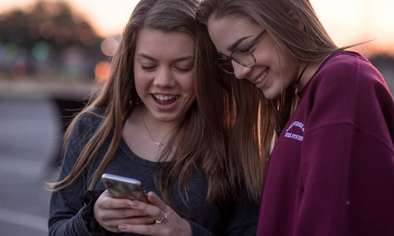 Two young ladies looking at a phone