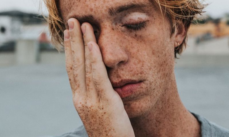 Man struggling with dry eyes, needing to visit GMHBA Eye Care