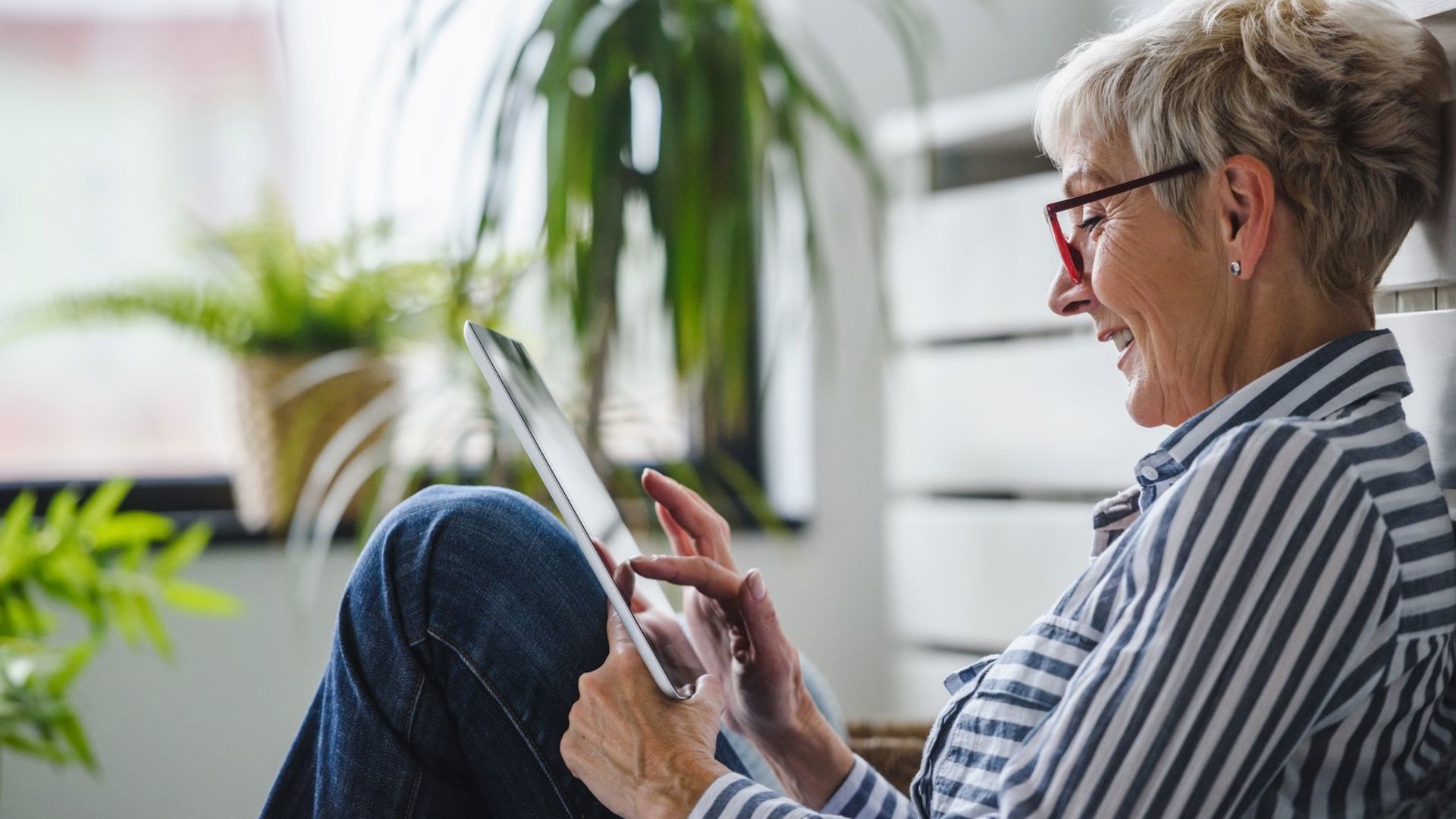 Mature woman using her ipad for a telehealth appointment that she can claim with GMHBA extras