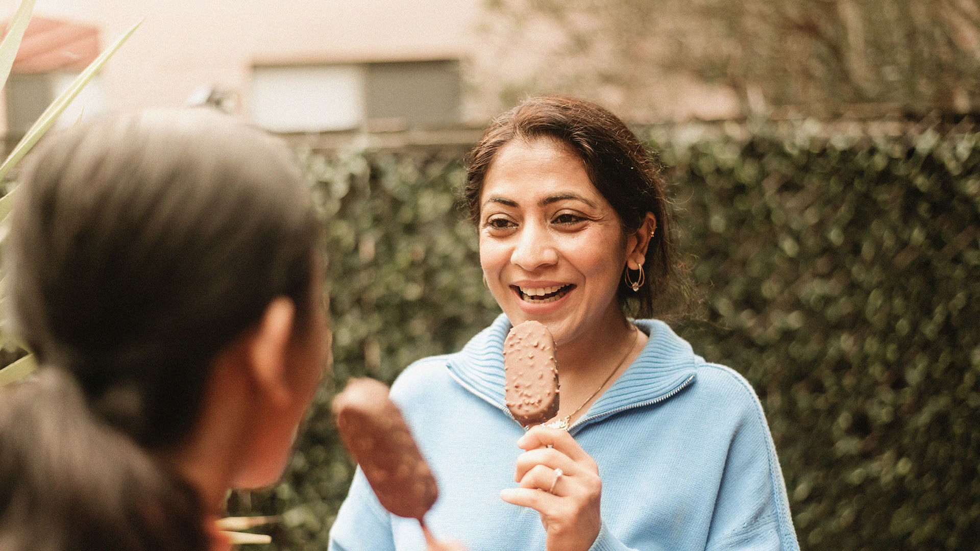 Mum and daughter eat ice cream in backyard - peace of mind because of Health Insurance
