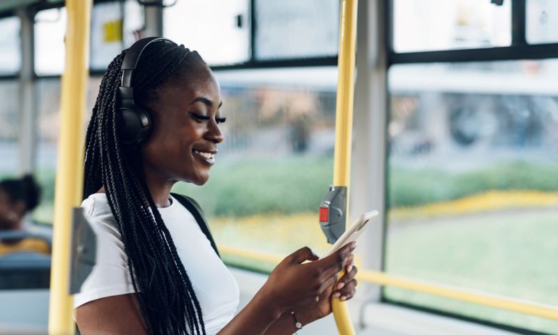 Girl on the bus using the GMHBA mobile app to make a claim on the go