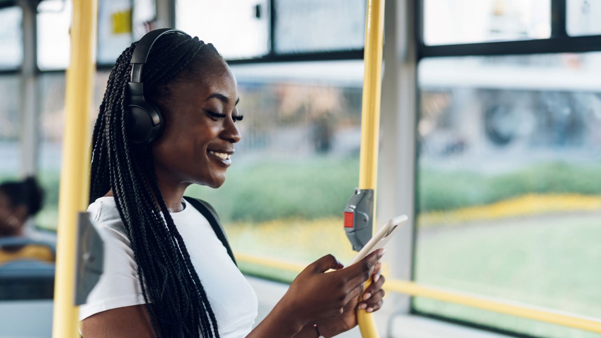 Girl on the bus using the GMHBA mobile app to make a claim on the go
