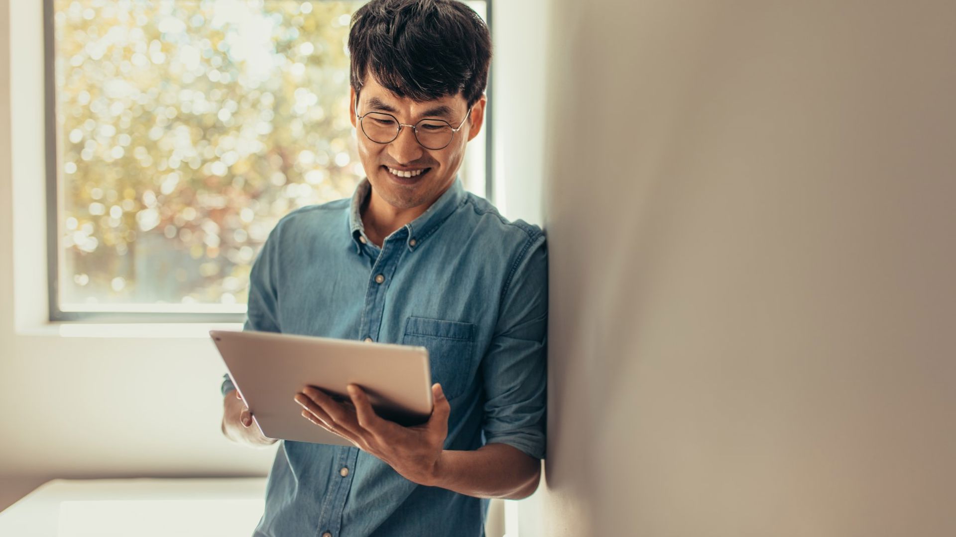 Smiling man using his ipad to register for the GMHBA member area