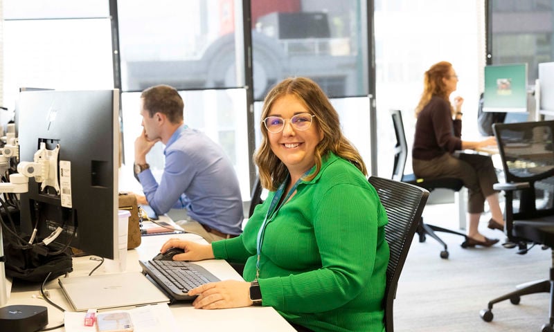 Happy GMHBA employee at desk in light filled office