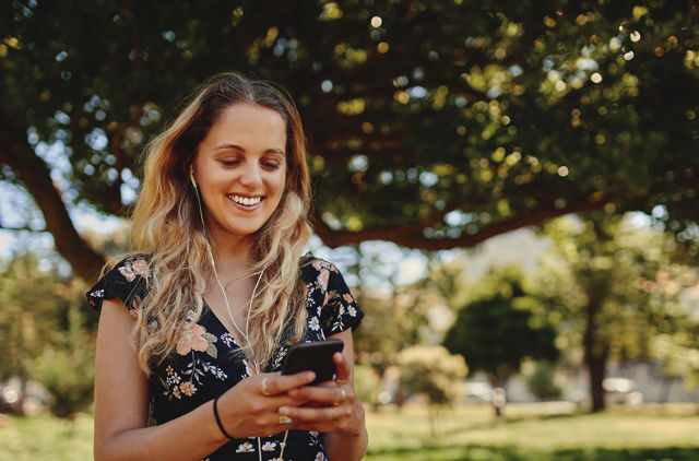 Woman listening to music in a summery park