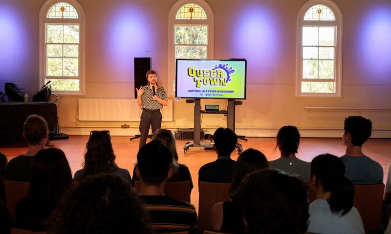 Archie Beetle, founder and director of Queer Town, delivering a LGBTIQA+ inclusion and allyship workshop in front of a crowd.