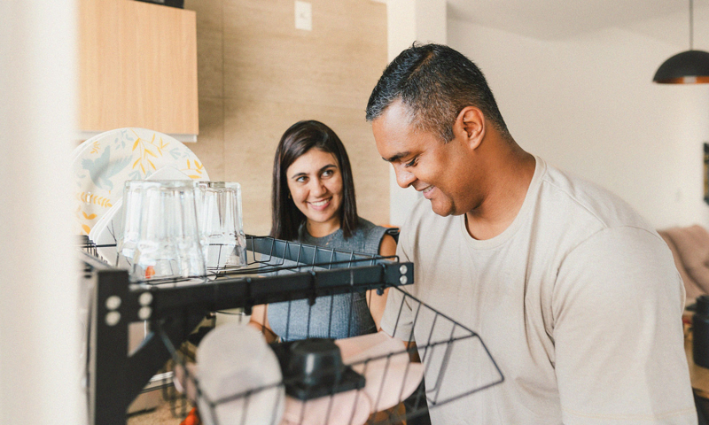 A happy couple washing up together in the kitchen