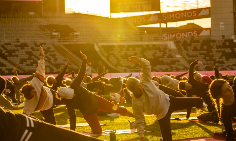 A group of people enjoying morning yoga at GMHBA Stadium