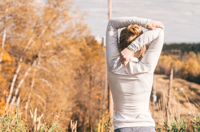 Woman stretching her back in field