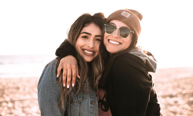 Two girls enjoying a sunny day out at the beach.