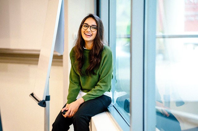 Young lady attending class smiling at her peers while at university