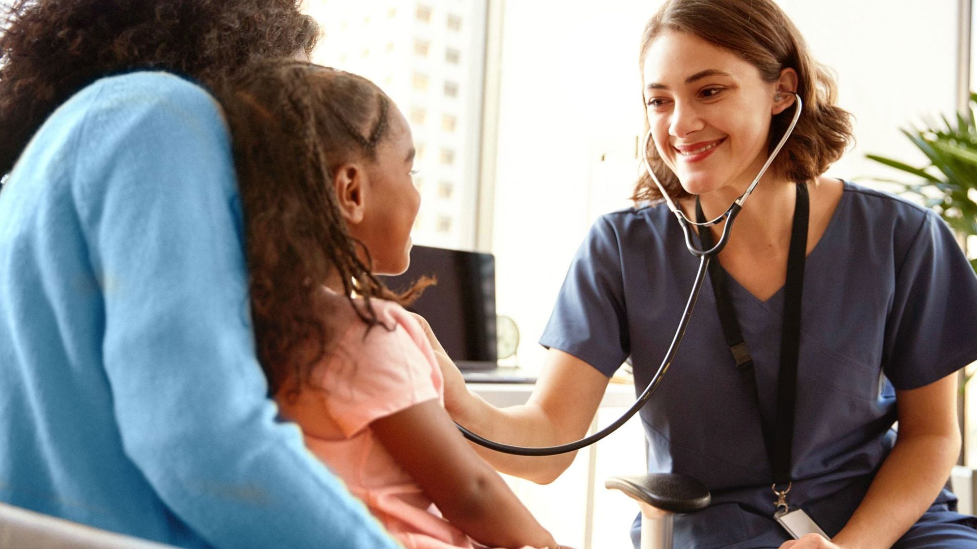 Mother sitting with child at the doctor while getting a general check up