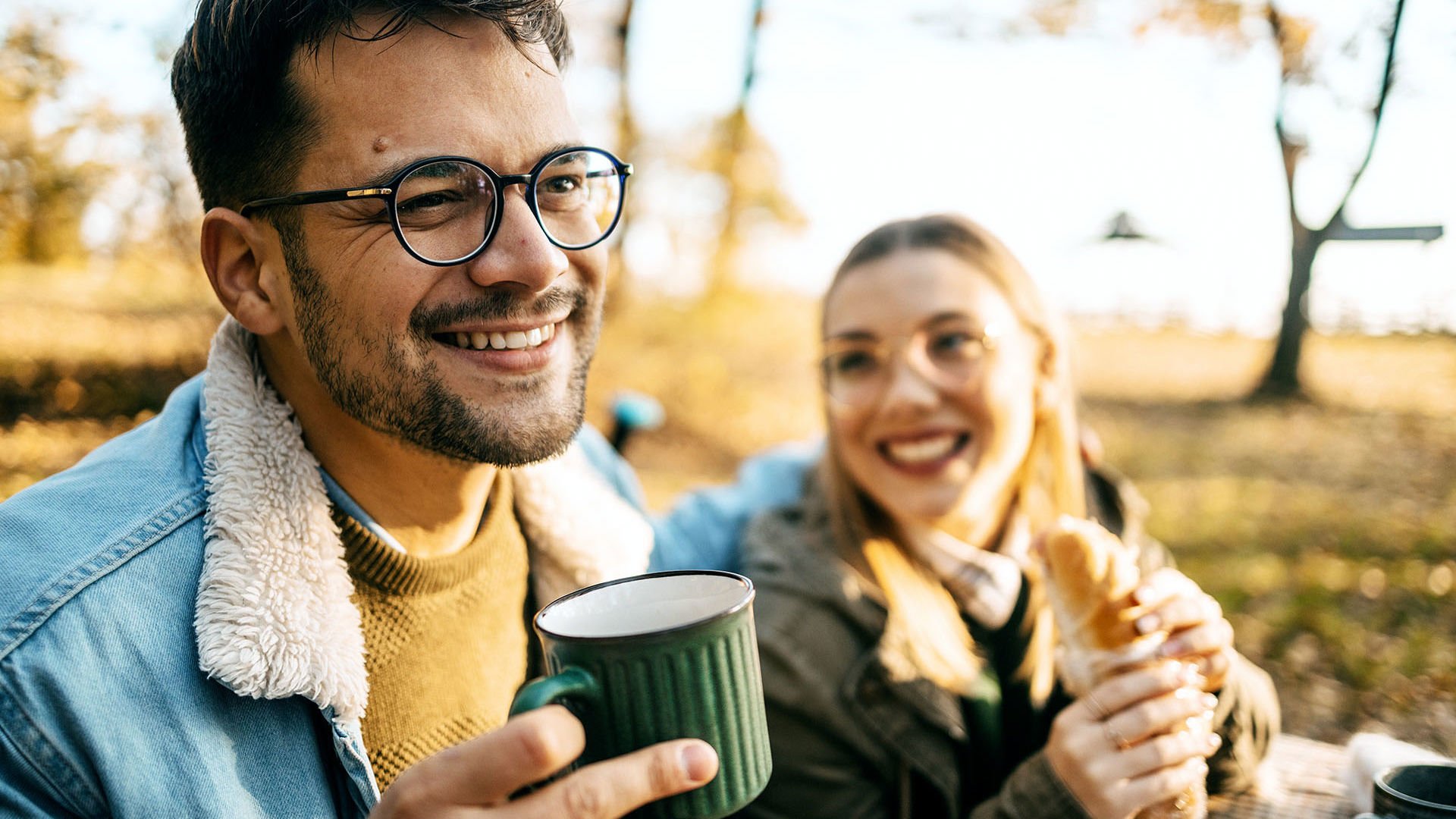 GMHBA extras member with new glasses having a coffee camping with friends