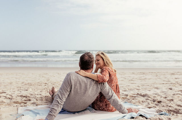 Over 60s couple relaxing on the beach with peace of mind for their private health insurance
