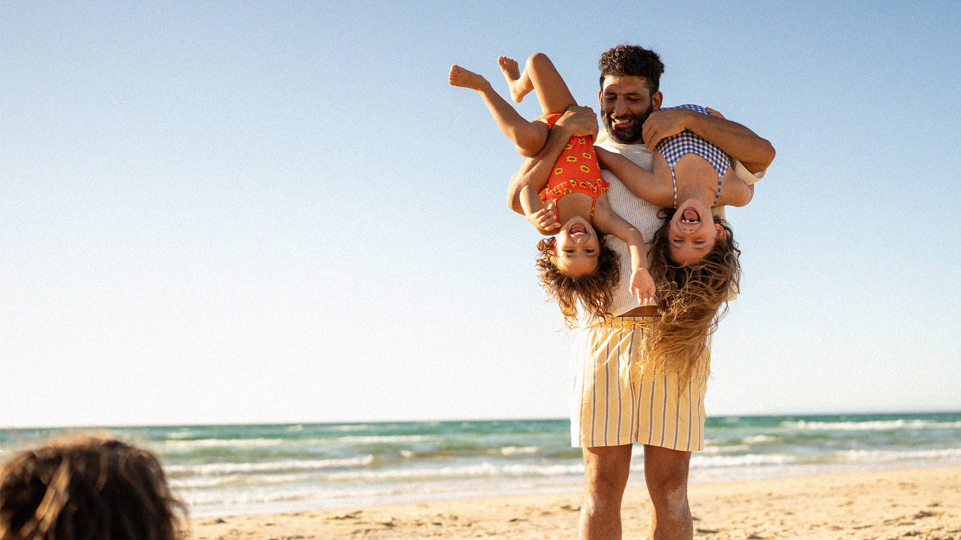 Dad playing with kids on the beach