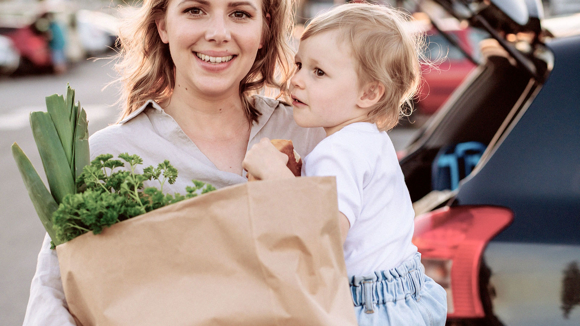 mother and baby grocery shopping in car park