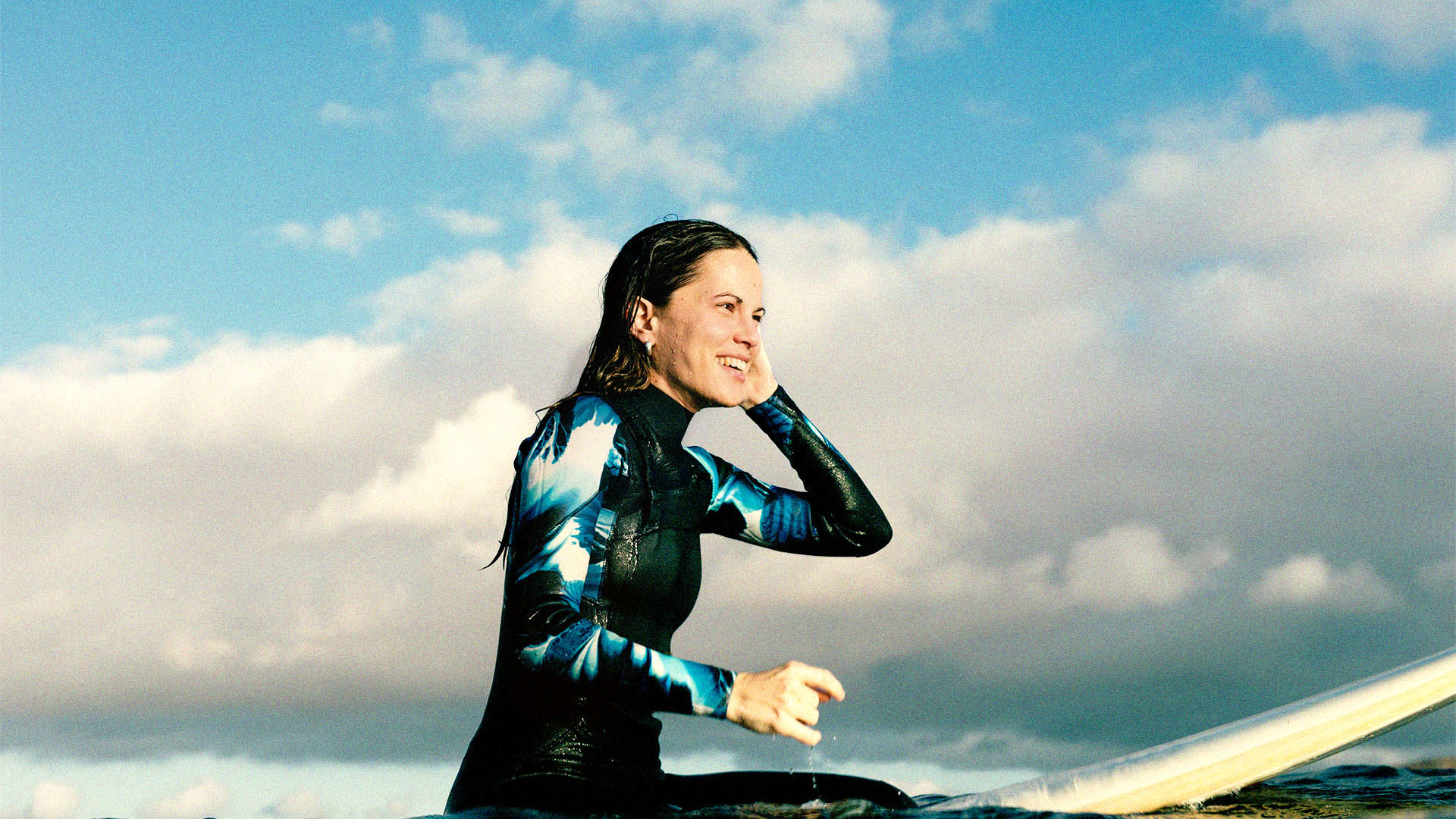 A young woman enjoying a surf out in the ocean on a sunny day