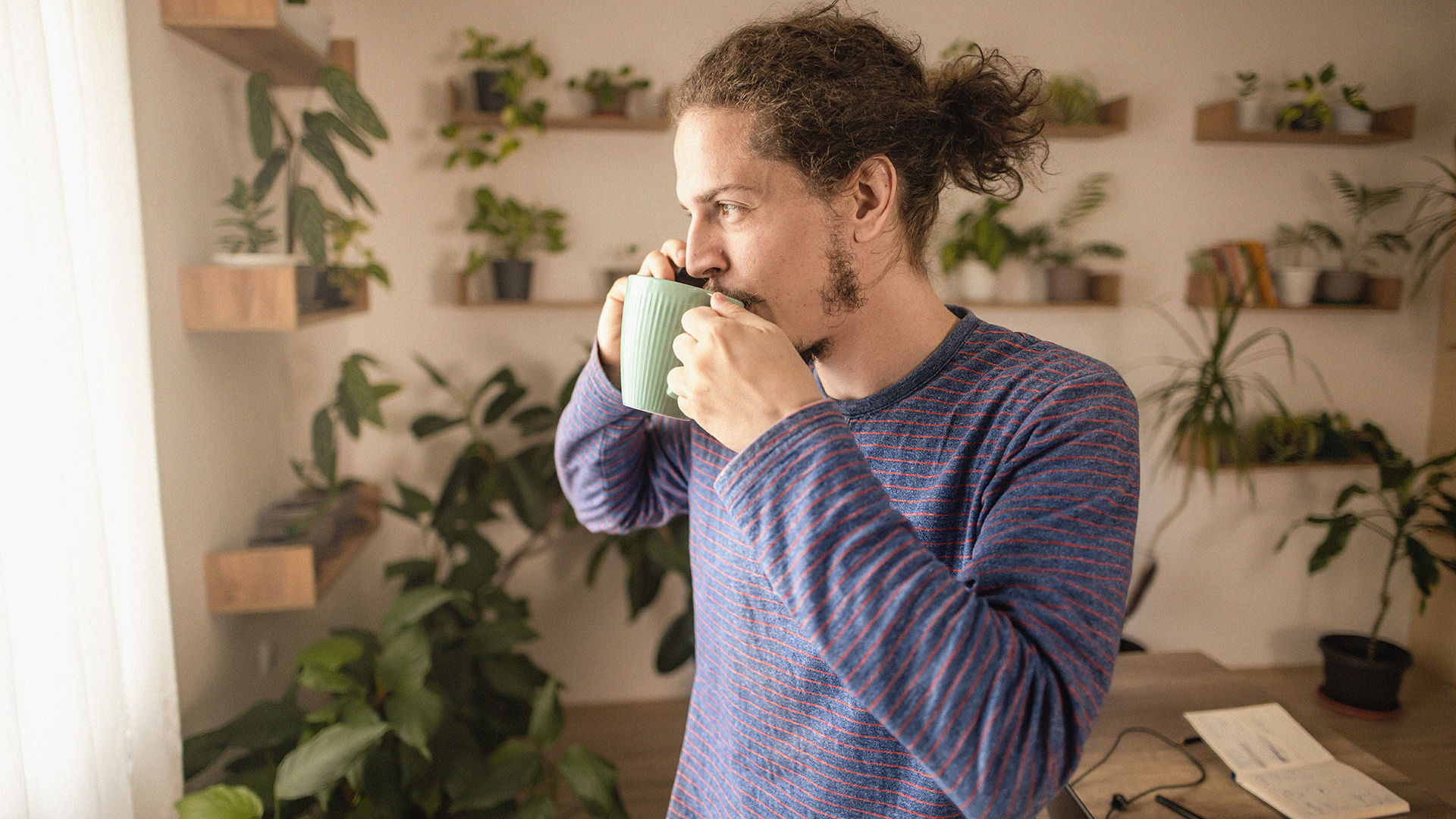 Man drinking his morning coffee on the phone to GMHBA health insurance