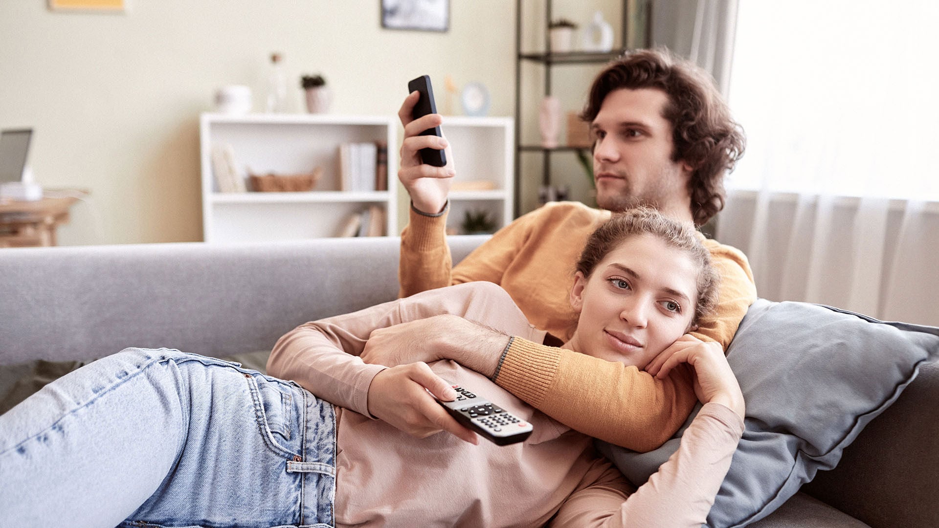 Two people relaxing on the couch looking at phones