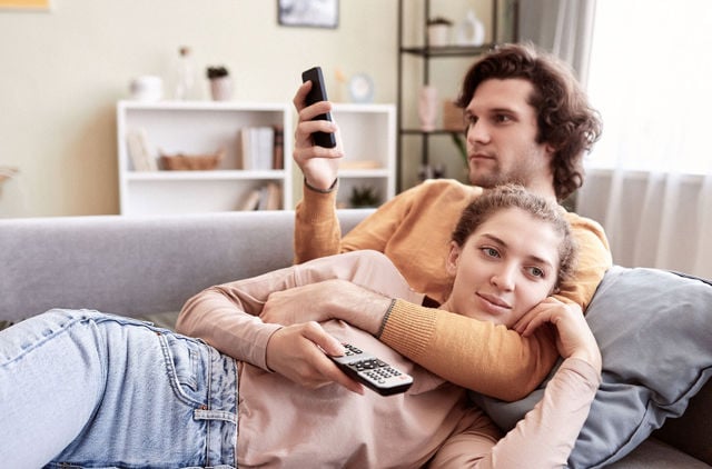 Two people relaxing on the couch looking at phones